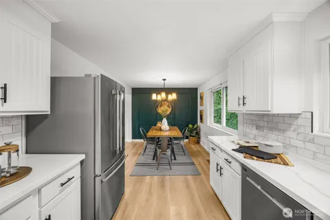 a kitchen with sink a refrigerator and wooden cabinets