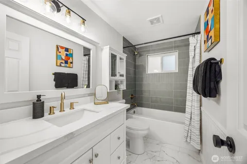 a bathroom with a sink a toilet a mirror and shower