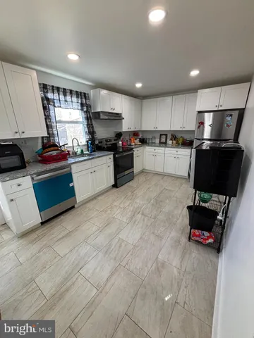 a kitchen with stainless steel appliances granite countertop a refrigerator sink and stove