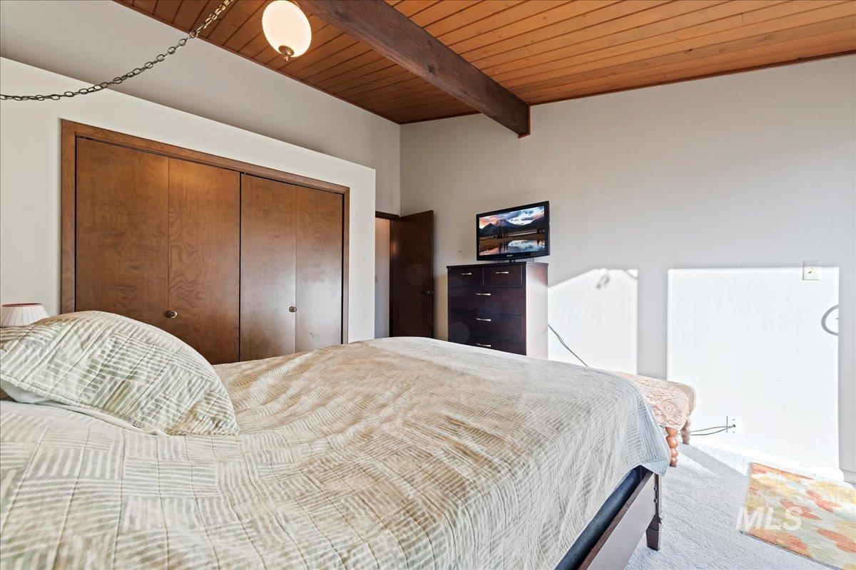 4747 Albion Street, Unit J Boise, ID 83705 - Photo 13 of 21 Carpeted bedroom featuring a wooden ceiling with exposed beams and a closet