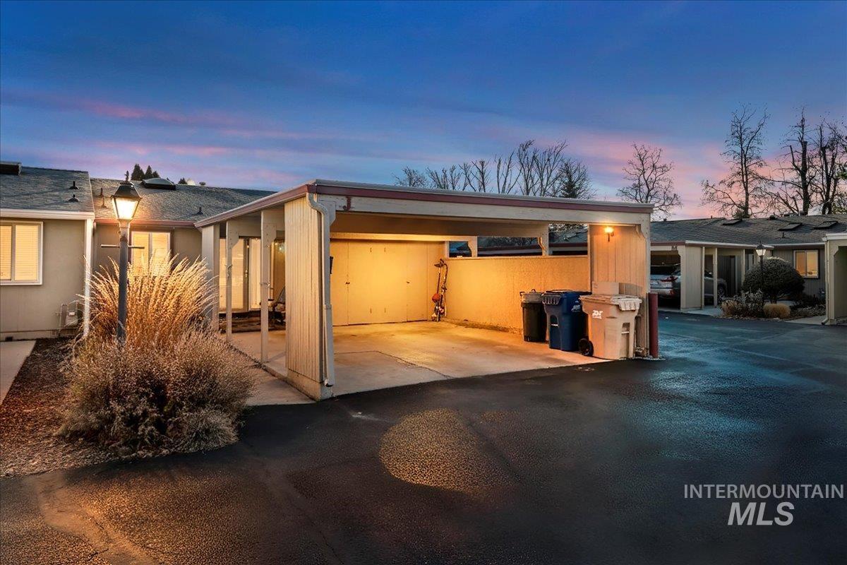 4747 Albion Street, Unit J Boise, ID 83705 - Photo 2 of 21 Garage at dusk featuring driveway and an attached carport