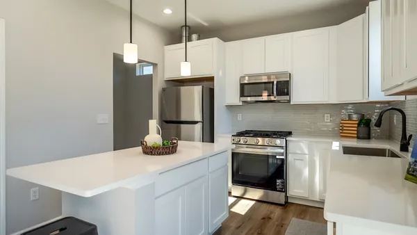a kitchen with stainless steel appliances a stove a sink a microwave a refrigerator a stove and cabinets