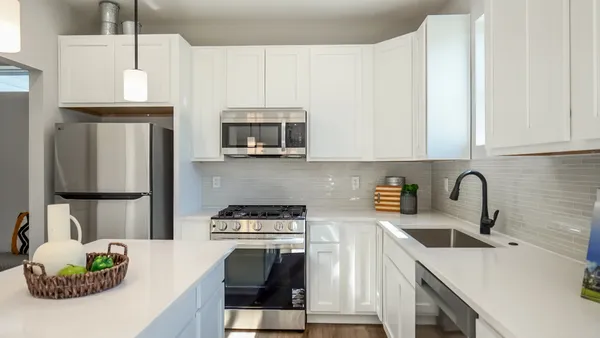 a kitchen with a sink stove and white cabinets