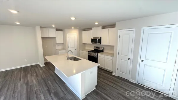 a kitchen with a sink a refrigerator and a stove top oven