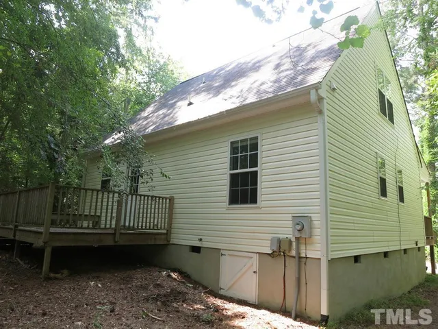 a view of a house with a wooden deck and a backyard