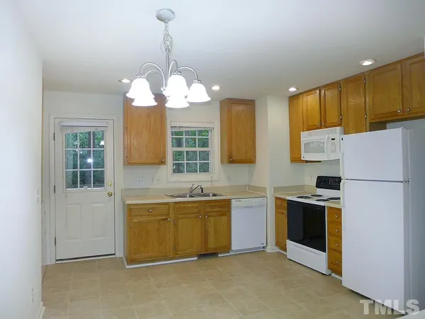 a kitchen that has a lot of cabinets and stainless steel appliances