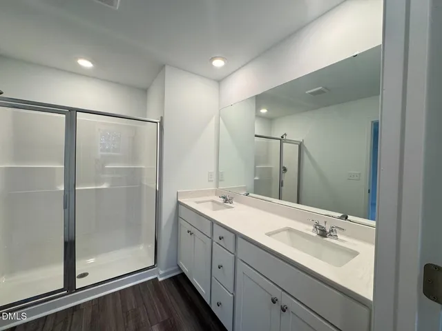 a bathroom with a double vanity sink mirror and shower