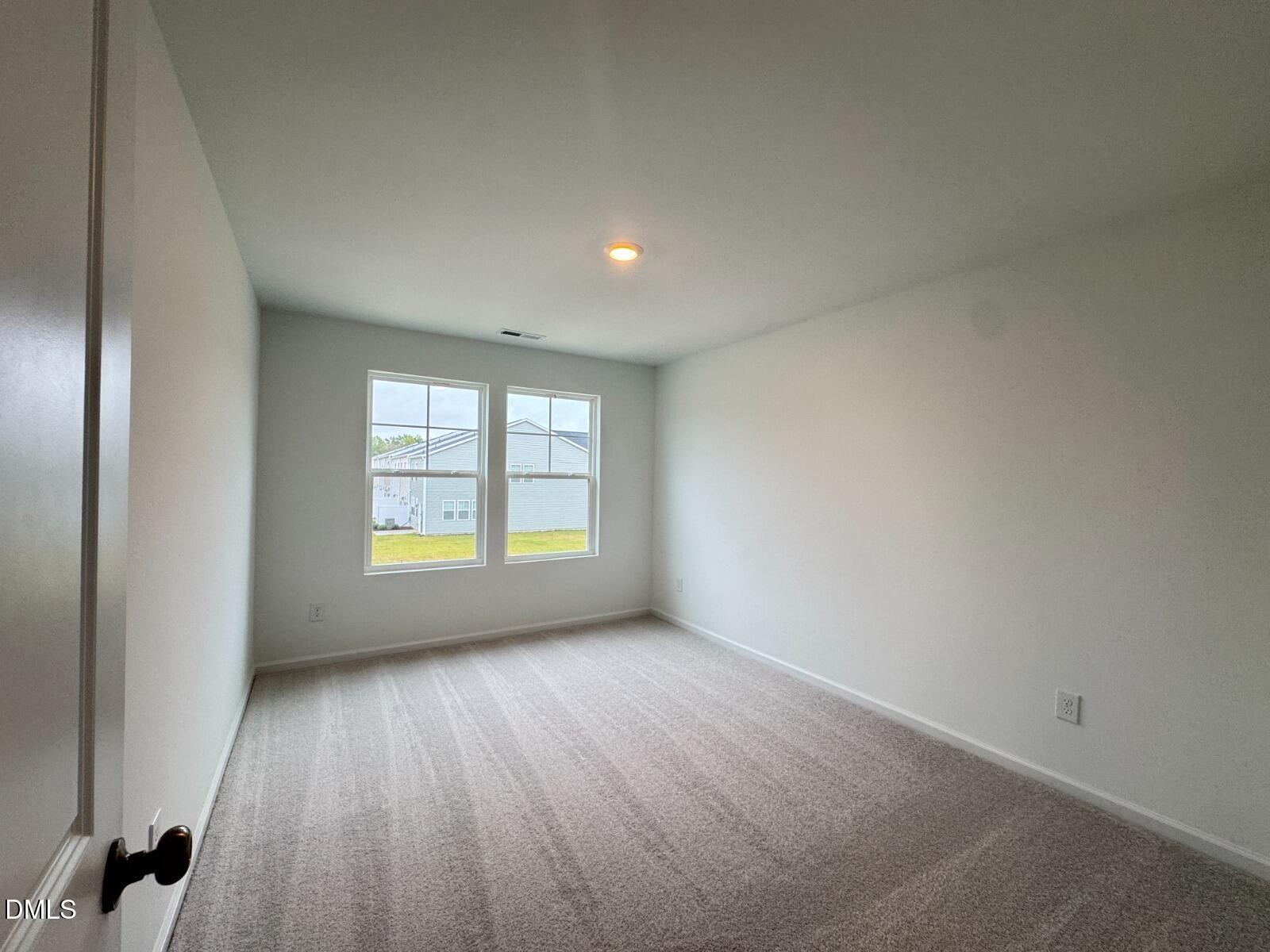 229 Lily Patch Lane Smithfield, NC 27577 - Photo 14 of 23 an empty room with wooden floor and windows