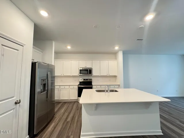 a kitchen with stainless steel appliances a refrigerator sink and cabinets