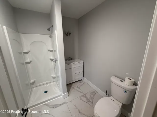 a bathroom with a toilet and a shower