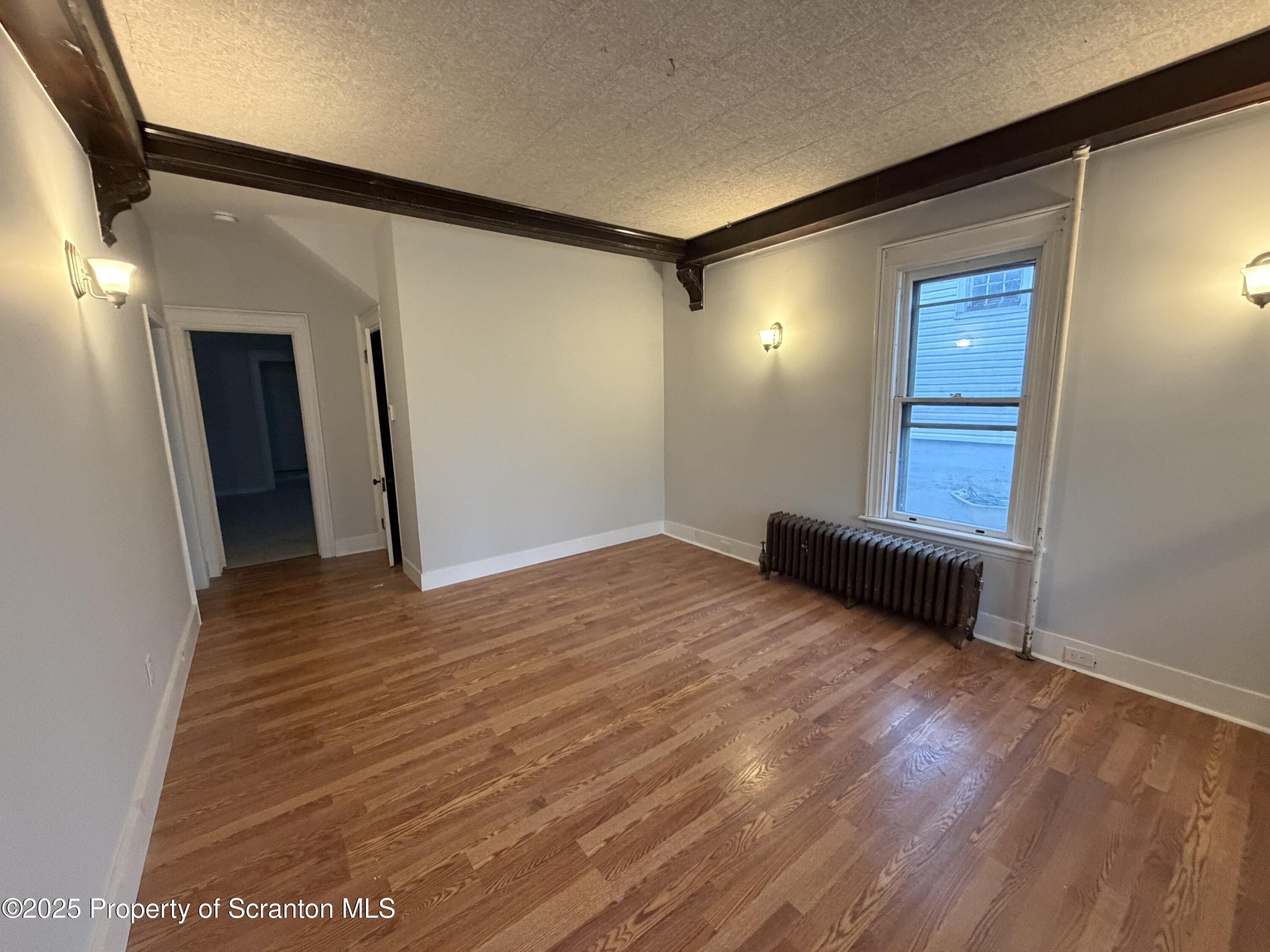 2105 Belmont Terrace, Unit 1 Scranton, PA 18508 - Photo 4 of 16 a view of an empty room with wooden floor and a window
