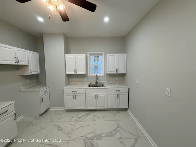 a large kitchen with kitchen island a sink stainless steel appliances and cabinets