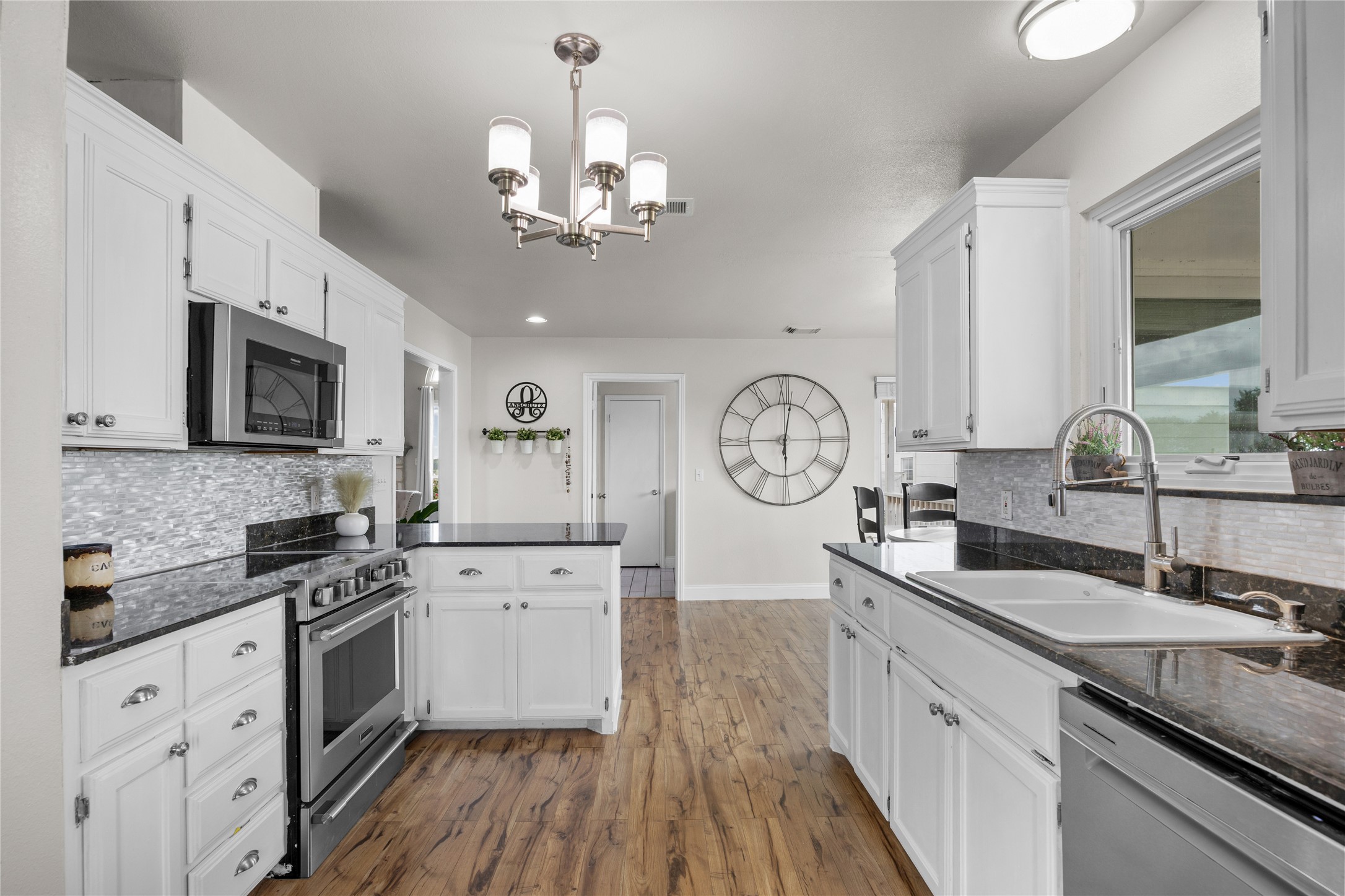 1283 Rattlesnake Trail Burnet, TX 78611 - Photo 20 of 39 a kitchen with granite countertop a sink dishwasher a stove top oven a clock with wooden floor