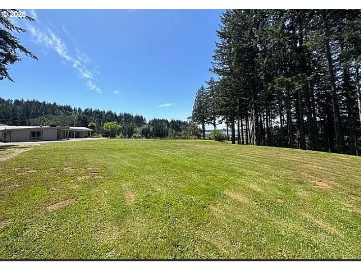 94475 Golf Course Lane North Bend, OR 97459 - Photo 31 of 45 a backyard of a house with lots of green space