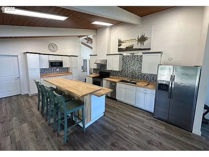 94475 Golf Course Lane North Bend, OR 97459 - Photo 9 of 45 a kitchen with a table chairs refrigerator and microwave