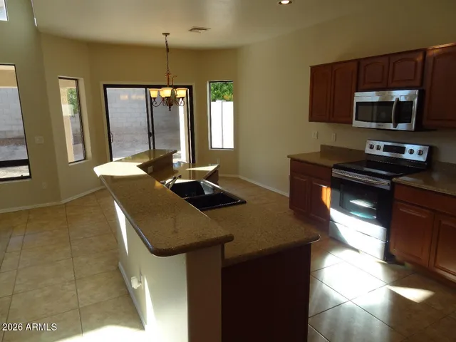 a kitchen with stainless steel appliances granite countertop a sink a stove and a microwave