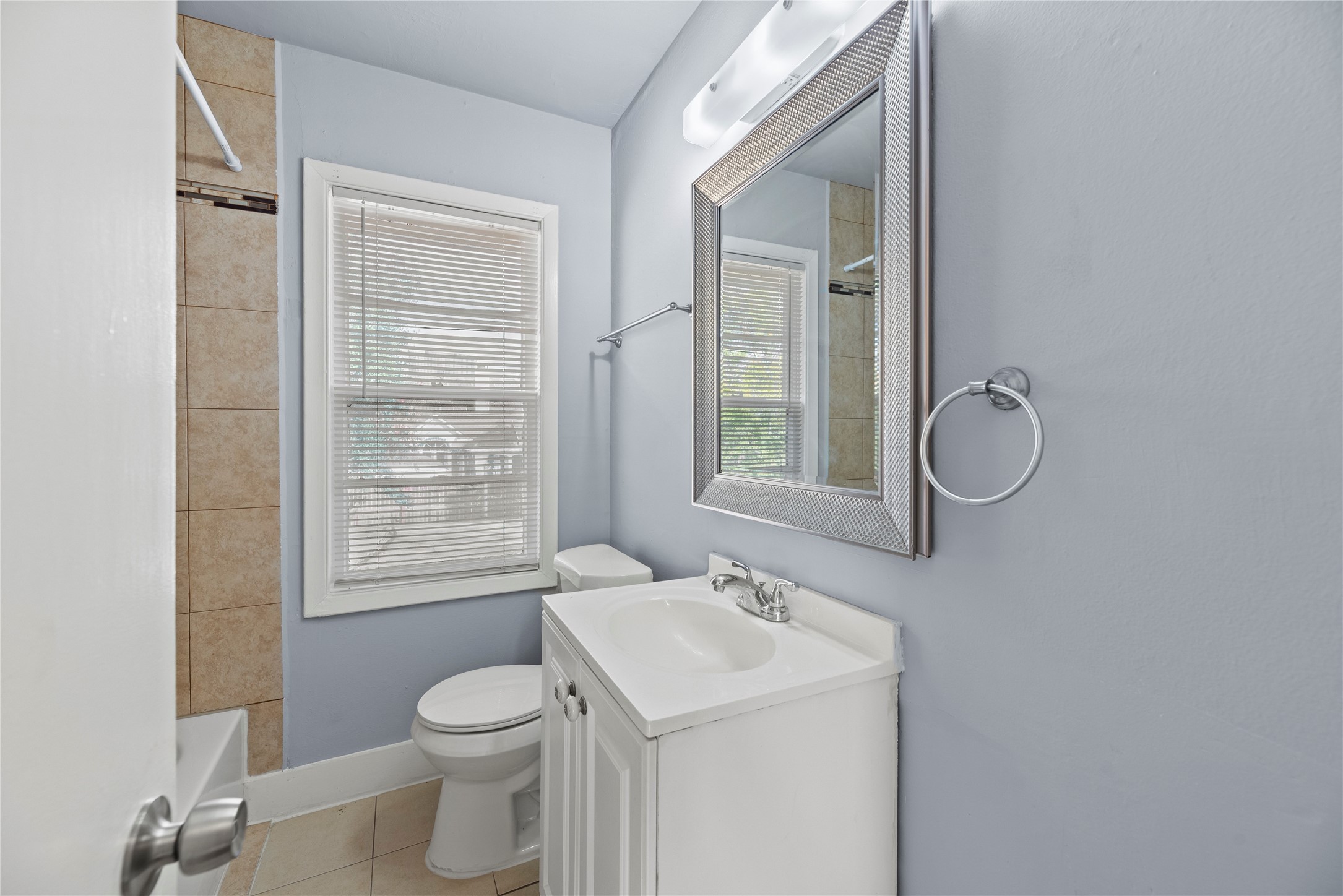 3930 Law Street, Unit 2 Houston, TX 77005 - Photo 13 of 16 a bathroom with a granite countertop toilet a sink and a mirror