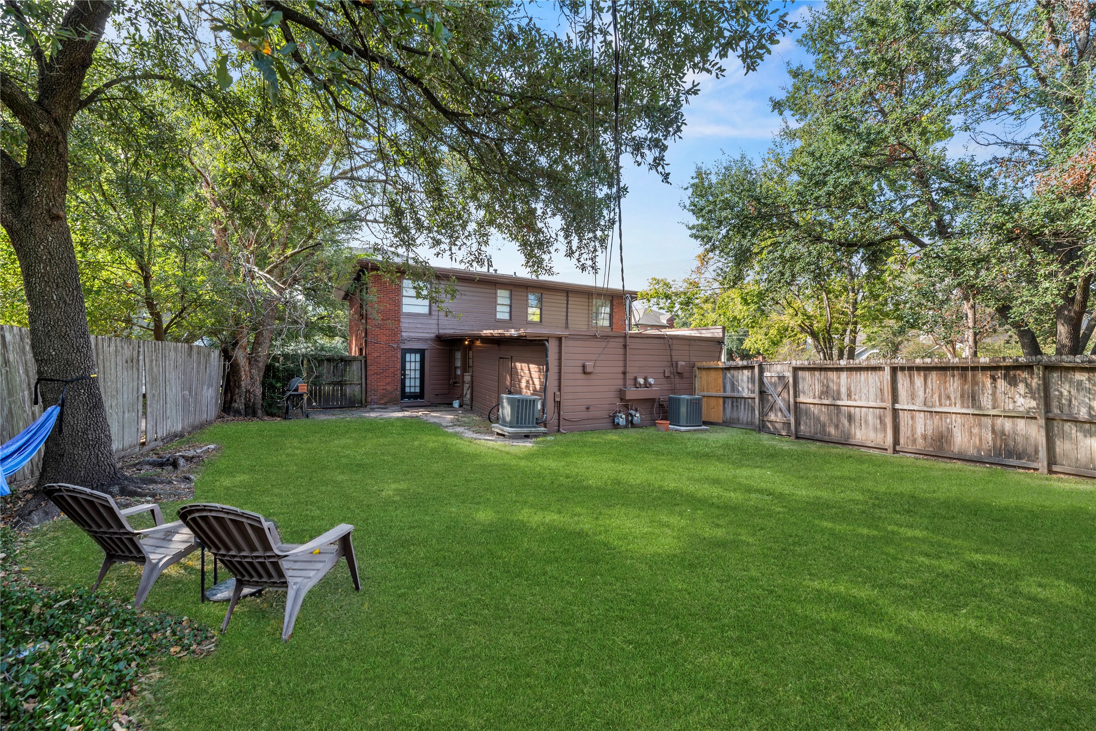 3930 Law Street, Unit 2 Houston, TX 77005 - Photo 14 of 16 a view of a backyard with table and chairs and a tree
