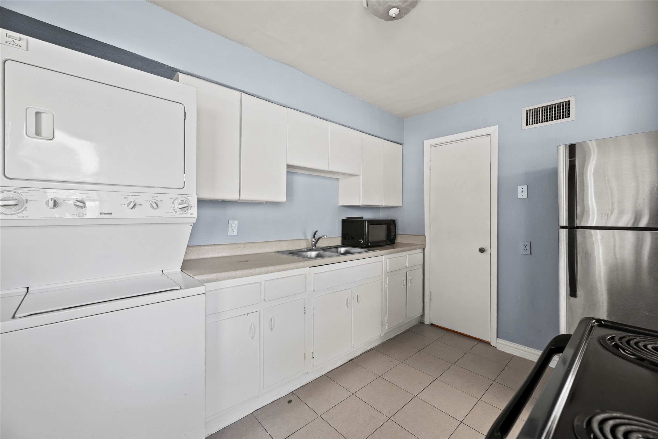 3930 Law Street, Unit 2 Houston, TX 77005 - Photo 6 of 16 a kitchen with white cabinets and white appliances