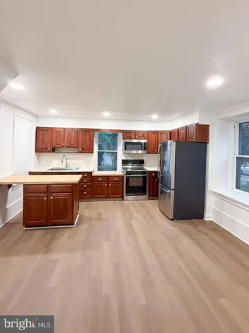 a large kitchen with a large counter top stainless steel appliances and cabinets