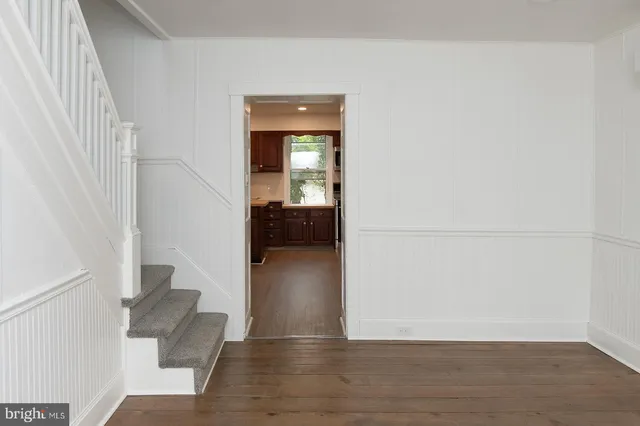 a view of a livingroom with wooden floor and staircase