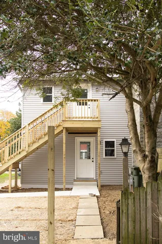 a front view of a house with a tree