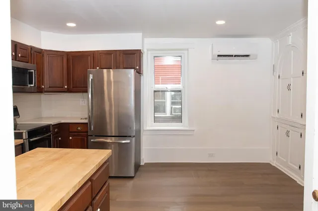 a kitchen with stainless steel appliances granite countertop a refrigerator and a stove top oven