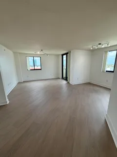 an empty room with windows and cabinet