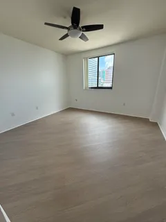 en empty room with windows and ceiling fan