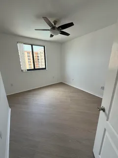 an empty room with windows and ceiling fan view