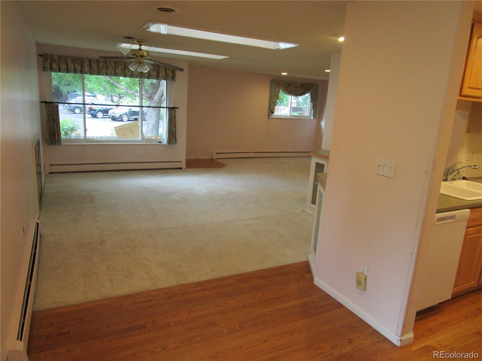 4 Nome Way, Unit A Aurora, CO 80012 - Photo 6 of 22 an empty room with wooden floor and windows