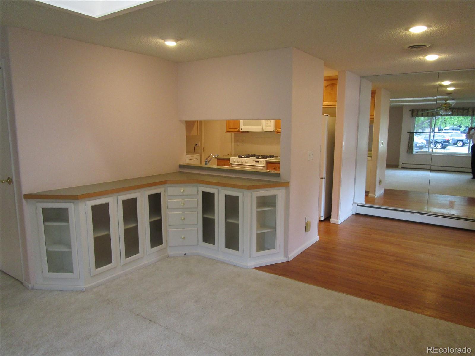 4 Nome Way, Unit A Aurora, CO 80012 - Photo 10 of 22 a view of an empty room with wooden floor and a kitchen
