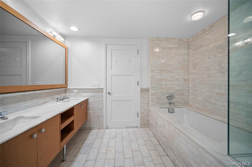 1 Renaissance Square, Unit 10E White Plains, NY 10601 - Photo 18 of 27 a spacious bathroom with a tub shower sink and mirror