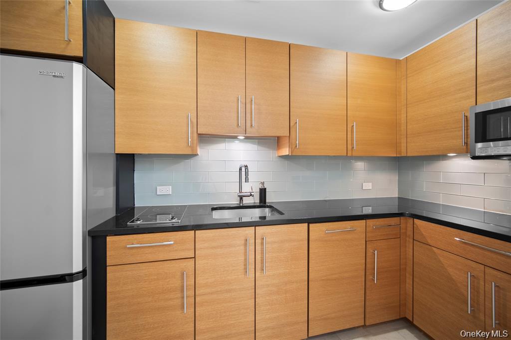 1 Renaissance Square, Unit 10E White Plains, NY 10601 - Photo 8 of 27 a kitchen with stainless steel appliances granite countertop a sink a stove and a refrigerator