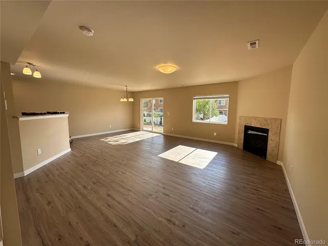 a view of empty room with wooden floor and window