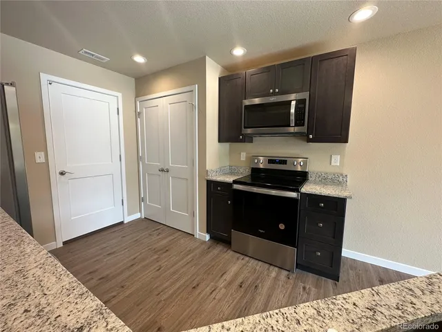 a kitchen with a refrigerator and a stove top oven