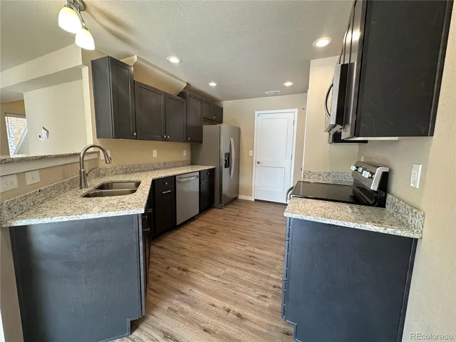 a kitchen with a sink stove top oven and refrigerator