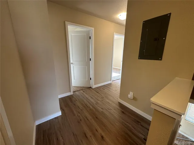 a view of a livingroom with wooden floor and bathroom