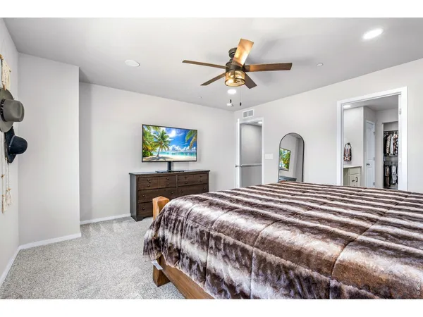 a bedroom with a bed a dresser and potted plants
