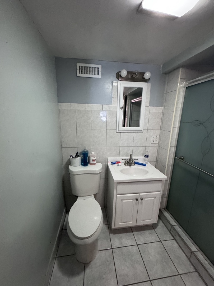 1940 North Pulaski Road Chicago, IL 60639 - Photo 28 of 33 a bathroom with a toilet sink and mirror