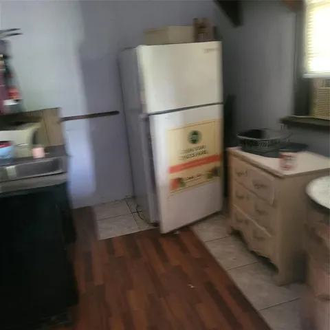 a white refrigerator freezer and a stove sitting inside of a kitchen