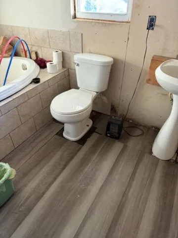 a white toilet sitting next to a bathroom sink and vanity