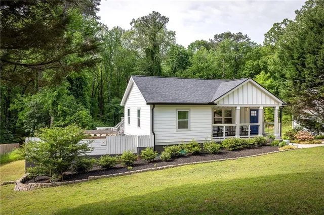 a front view of a house with a yard and trees
