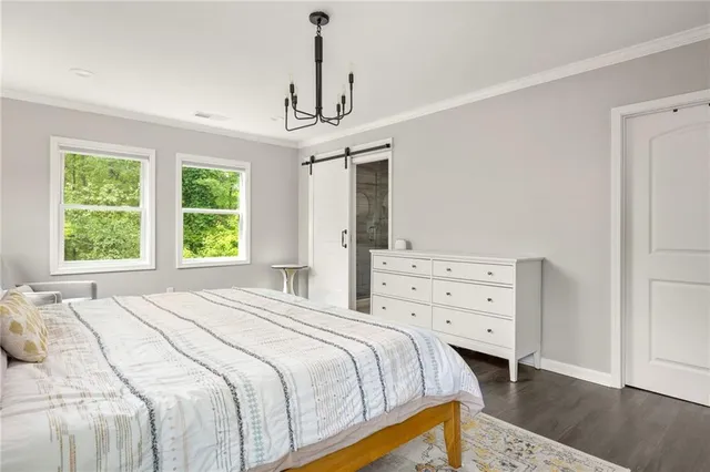 a bedroom with a bed a chandelier and a window