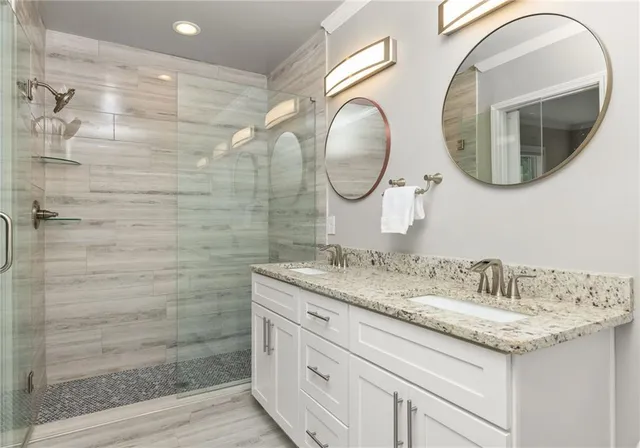 a bathroom with a granite countertop double vanity sink and a mirror