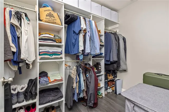 a view of walk in closet with clothes and shoes
