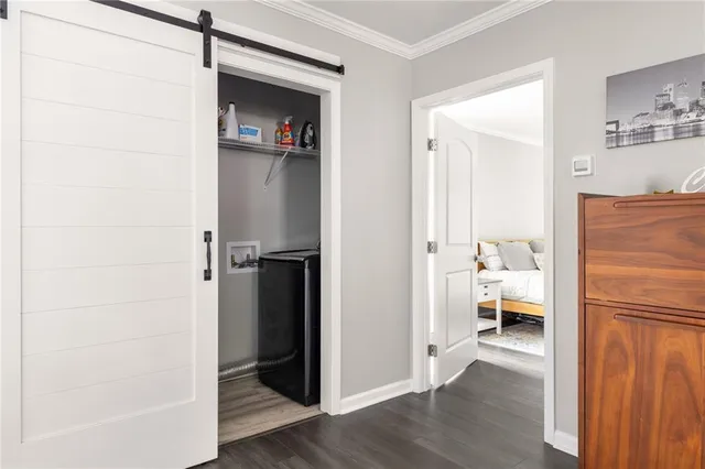 a walk in closet with wooden floor