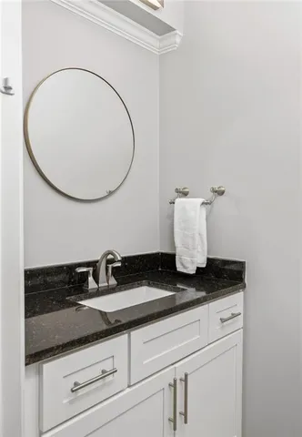 a bathroom with a granite countertop sink and mirror
