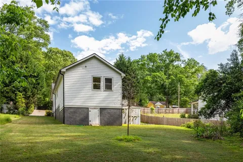 a view of a house with a yard and sitting area