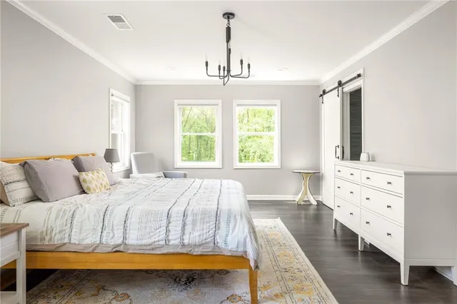 a bedroom with a bed dresser and wooden floor